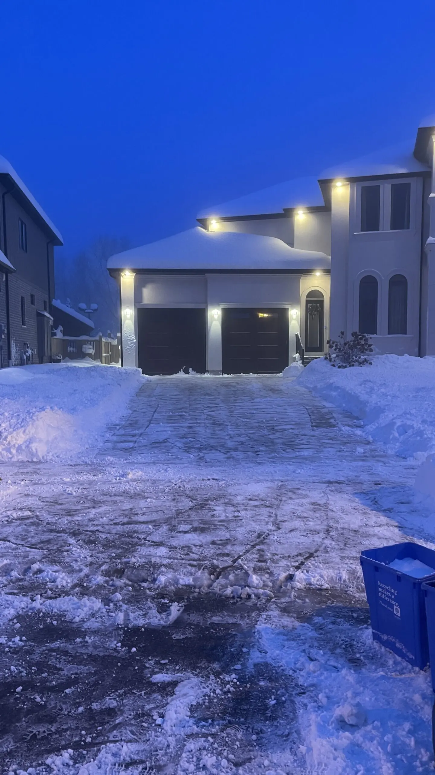 Snow removal crew shoveling walkway and sidewalk in London, Ontario neighborhood