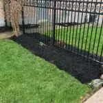 Black mulch installation around home landscaping in London Ontario